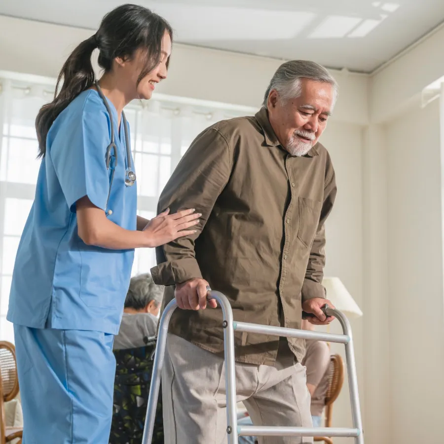 Pflege und Gesundheitswesen – Steuerberatung Düsseldorf Pflegekraft unterstützt einen Senior mit Rollator